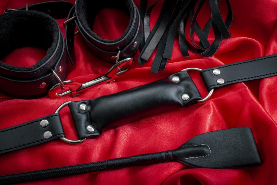 BDSM toys on red sheets